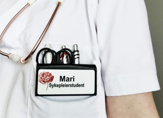 bilde av sykepleierstudent Mari på jobb med skilt, Cingulum AS